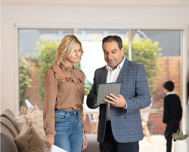 EST Property advisor reviewing costs and property details with client in home interior.